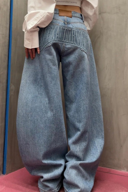Locker geschnittene, bodenlange Jeans mit geschwungenem Bein und gewaschenem, geprägtem Buchstabenmuster